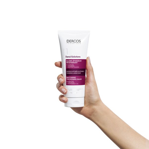 Producto dercos bálsamo regenerador en la mano