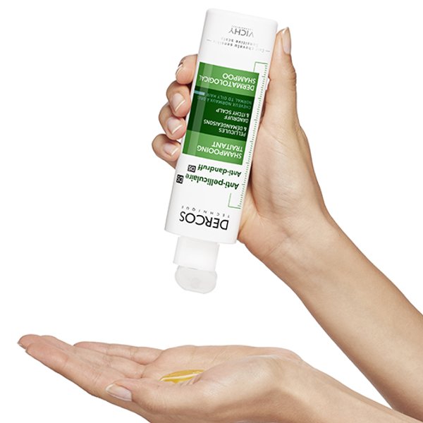 persona aplicandose en las manos shampoo anti caspa